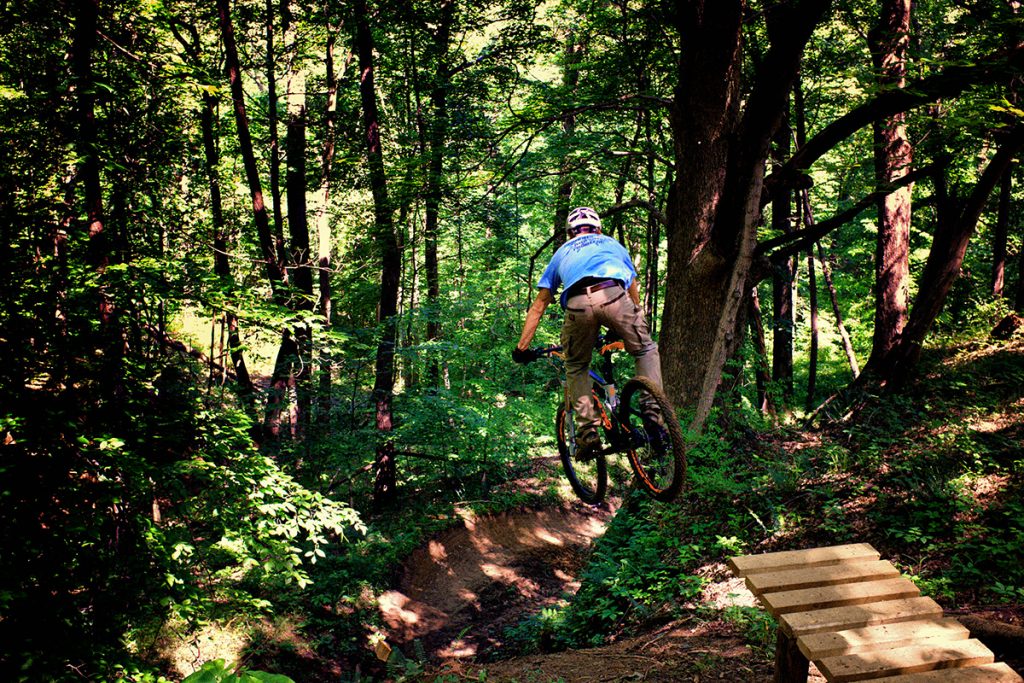 Mountain biker Daniel Goldbach goes off a jump into a deep ravine at Harmonie State Park's Mountain Bike Trail.