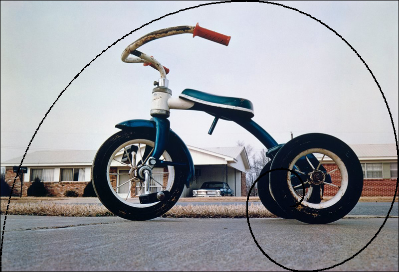 Eggleston photo of red tricycle with golden ration overlay